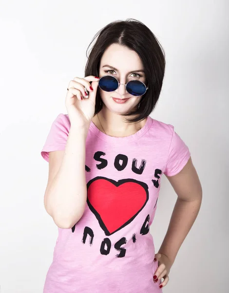 Hermosa joven con gafas de sol redondas azules. Tocando gafas . — Foto de Stock