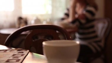 Çay veya kahve içme ve gülümseyen kafede oturan genç ve güzel kadın