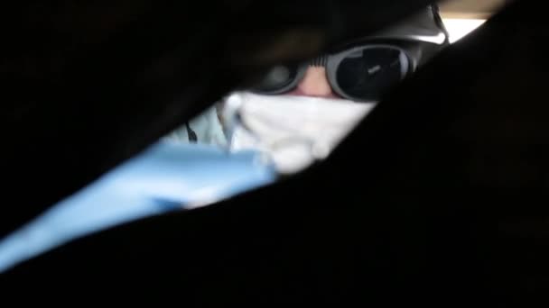 Cirurgião em um capacete com chifres e óculos faz uma incisão e olhando cauteloso para uma veia importante para operar, segura um bisturi e seringa — Vídeo de Stock