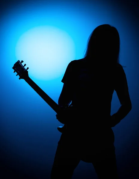 Silueta kytaristy rockové kapely s kytarou na modrém pozadí — Stock fotografie