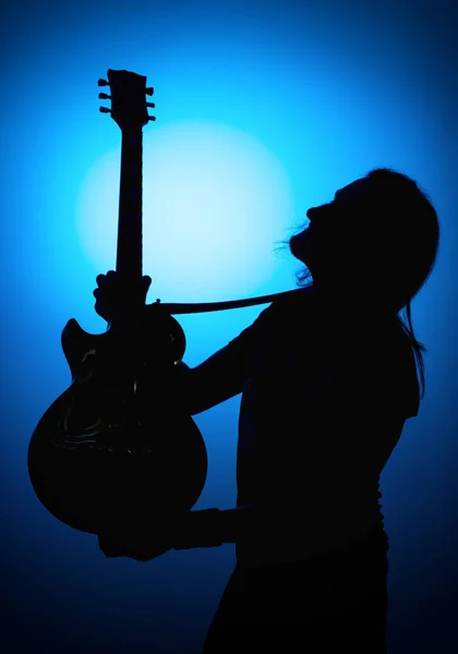 Silhueta guitarristas de uma banda de rock com guitarra sobre fundo azul — Fotografia de Stock