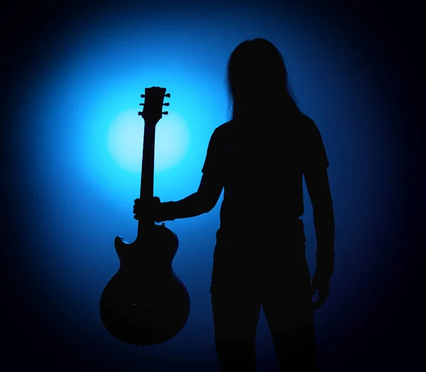 Silhouette gitarrister i ett rockband med gitarr på blå bakgrund — Stockfoto