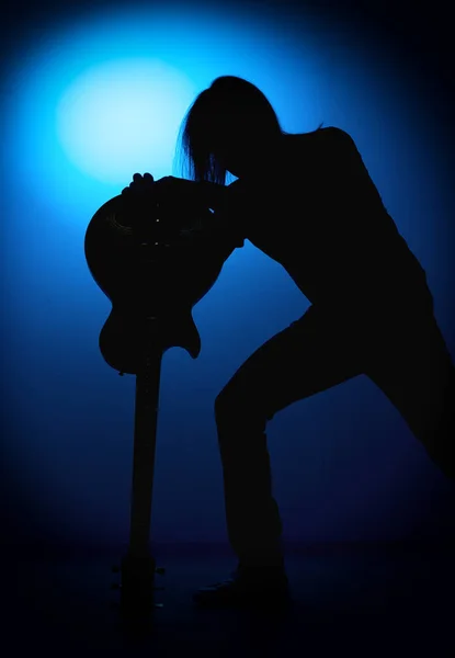 Silhouette guitaristes d'un groupe de rock avec guitare sur fond bleu — Photo