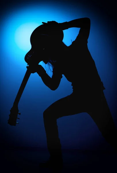 Silhueta guitarristas de uma banda de rock com guitarra sobre fundo azul — Fotografia de Stock