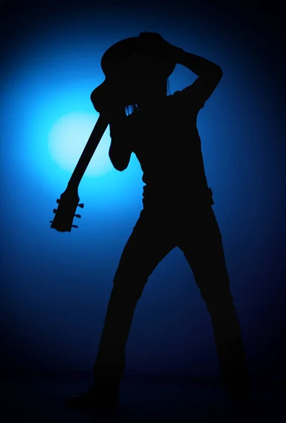 Silhouette guitarists of a rock band with guitar on blue background — Stock Photo, Image