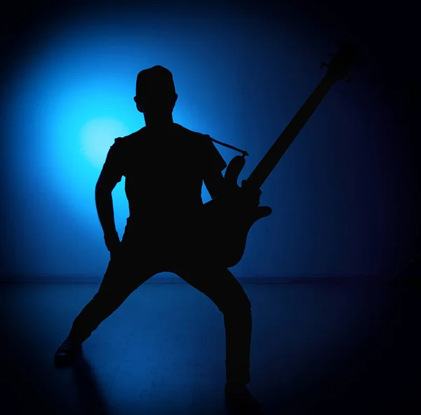 Σιλουέτα κιθαρίστες της ένα ροκ συγκρότημα με κιθάρα σε μπλε φόντο — Φωτογραφία Αρχείου