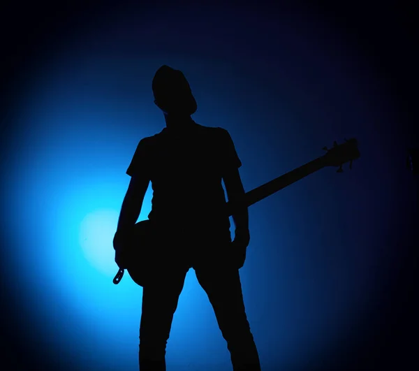 Silhouette gitarrister i ett rockband med gitarr på blå bakgrund — Stockfoto