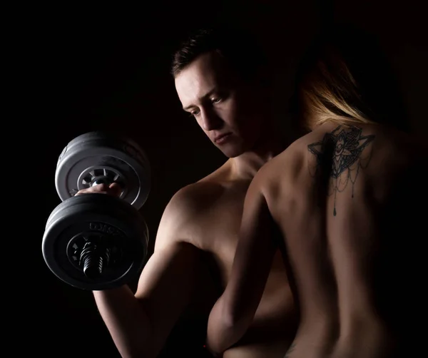 Красива молода спортивна сексуальна пара показує м'язи на темному тлі — стокове фото