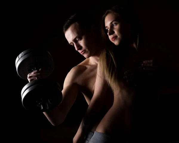 Belo jovem desportivo sexy casal mostrando muscular em um fundo escuro — Fotografia de Stock