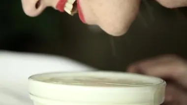 Close-Up bir kedi gibi süt içme dantel maskeli genç seksi bir kadın. gülümseyen kız lepleme yoğurt cam kase