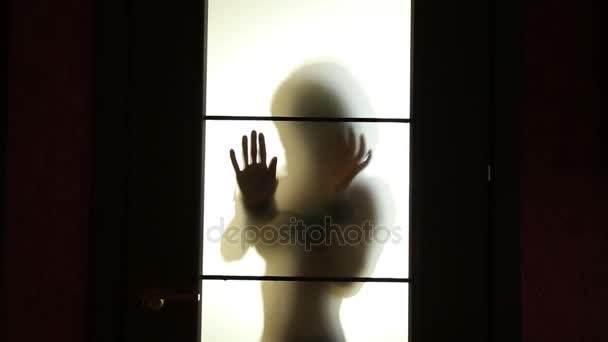 Seductive Woman dances behind blurry glass door, sexually holding handcuffs — Stock Video