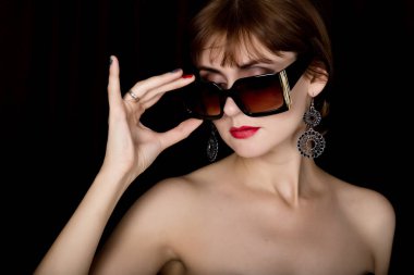 Boyutu güneş gözlüğü üzerinde tutarak uzun deri eldiven, profesyonel makyaj güzellik retro kadın modeliyle