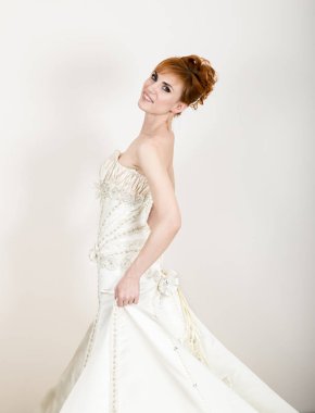 Profesyonel makyaj ve saç modeli ile beyaz gelinlik giyen güzel genç Kızıl saçlı gelin