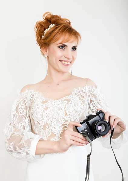 Pengantin wanita berambut merah muda yang cantik mengenakan gaun pengantin putih dengan riasan profesional dan gaya rambut. memegang kamera — Stok Foto