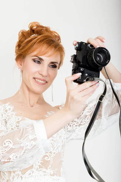 Schöne junge rothaarige Braut in weißem Hochzeitskleid mit professionellem Make-up und Frisur. Haltekamera — Stockfoto