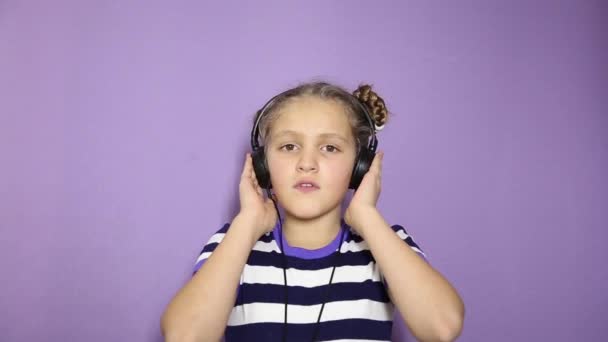 Junges Mädchen mit Zöpfen hört Musik über Kopfhörer und tanzt — Stockvideo