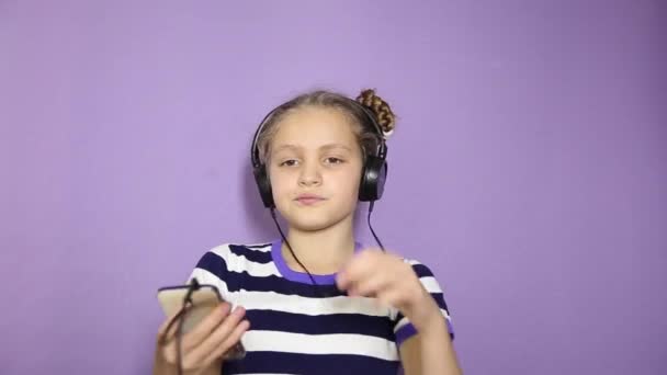 Mladá dívka s copánky poslech hudby ve sluchátkách a tanec — Stock video