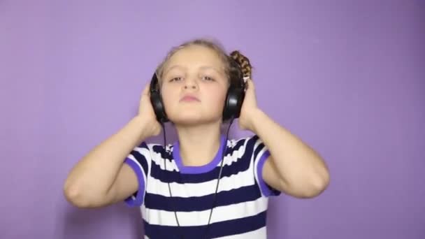Fiatal lány pigtails fejhallgató a zene és a tánc — Stock videók