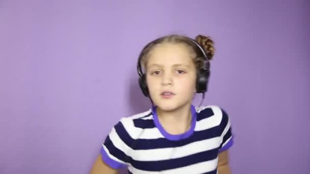 Niña con coletas escuchando música en los auriculares y bailando — Vídeo de stock