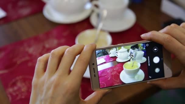 Donna alla moda in un ristorante fare foto di cibo con fotocamera del telefono cellulare per i social network — Video Stock