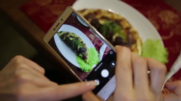 Модна жінка в ресторані робить фото їжі з камерою мобільного телефону для соціальної мережі — стокове відео