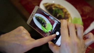 Bir restoranda trendy kadın olun fotoğraf gıda ile hareket eden telefon fotoğraf makinesi için sosyal ağ