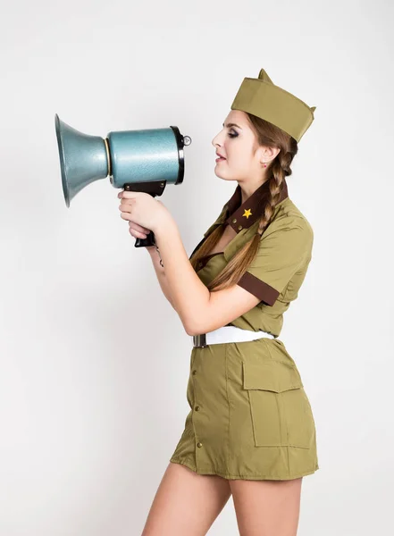 Sexy módní žena ve vojenské uniformě a garrison cap, drží bullhorn a křičí — Stock fotografie