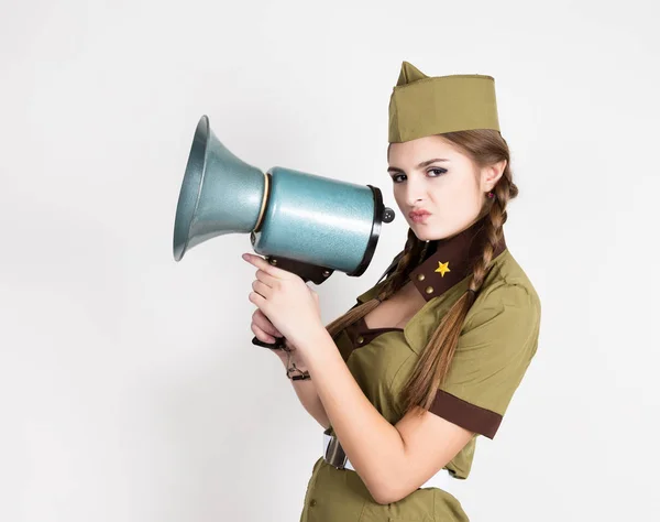 Sexy módní žena ve vojenské uniformě a garrison cap, drží bullhorn a křičí — Stock fotografie