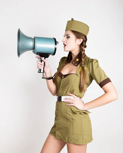 Sexy módní žena ve vojenské uniformě a garrison cap, drží bullhorn a křičí — Stock fotografie