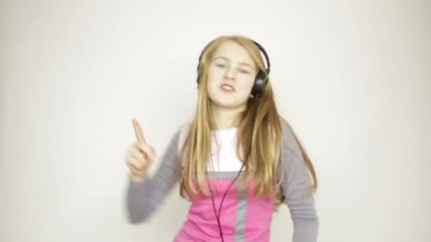 Mladá dívka poslech hudby na sluchátka a funy tanec — Stock video