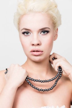 Profesyonel makyaj holding gri pearl ile beyaz elbise giyen güzel sarışın gelin