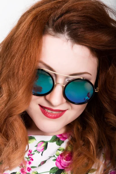 Jovem elegante mulher ruiva com cabelo encaracolado e rosto bonito posando em óculos de sol. expressa emoções diferentes — Fotografia de Stock