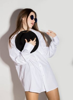 çıplak kız bir beyaz gömlek, güneş gözlüğü ve siyah şapka mans