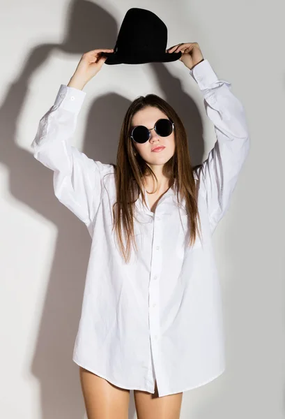 Menina nua em um homem camisa branca, óculos de sol e chapéu preto — Fotografia de Stock