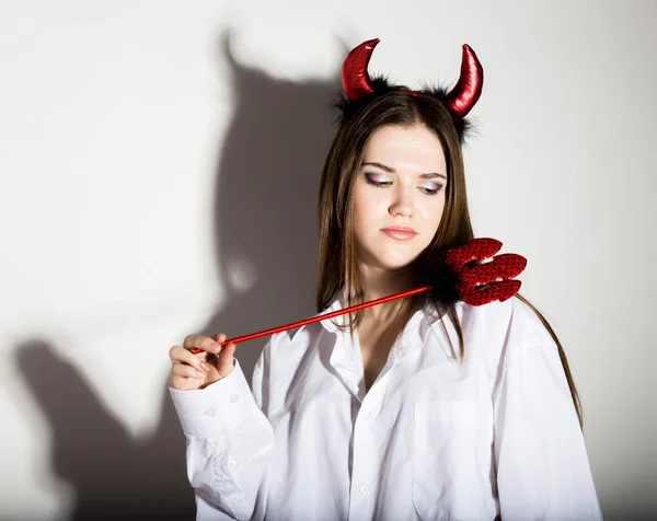 Fiatal lány egy mans vörös szarv néz szép ördög fehér ing — Stock Fotó