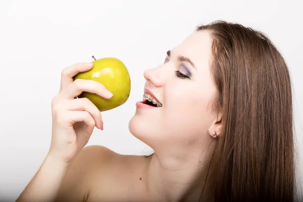 Retrato de menina adolescente mostrando aparelho dental e segurando maçã — Fotografia de Stock
