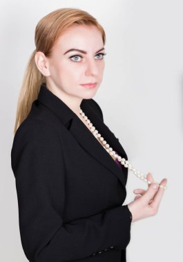 Gülümseyerek, inci holding çıplak vücut üzerinde takım elbiseli çekici ve enerjik iş kadını