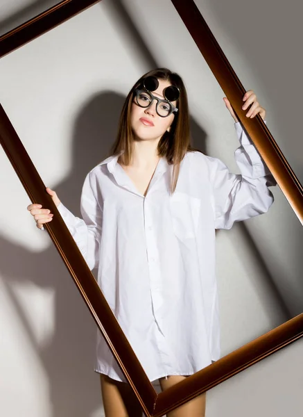 裸体女孩在勒芒白衬衫，拿着木制框架太阳镜 — 图库照片