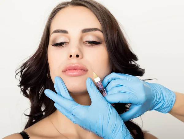 Närbild av vacker ung kvinna får injektion i ögonen och läpparna från kosmetolog. kosmetologi koncept — Stockfoto
