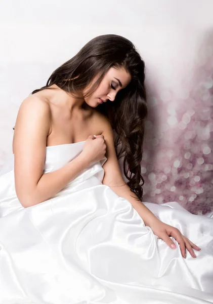 Mooie vrouw in peignoir slapen op bed onder zijden lakens — Stockfoto