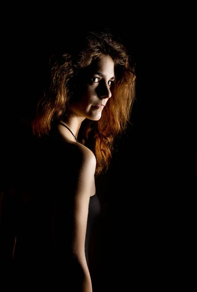 Elegant curves of female shoulders and neck, Redhead girl on a dark background