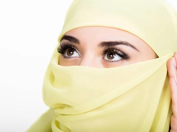 Азиатка с карими глазами, позирующая в жёлтом шарфе, мусульманская модель в хиджабе на белом фоне — стоковое фото