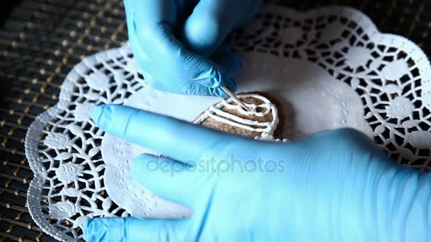 Female hands decorating gingerbread stocking with icing sugar using selfmade pastry bag — Stock Video