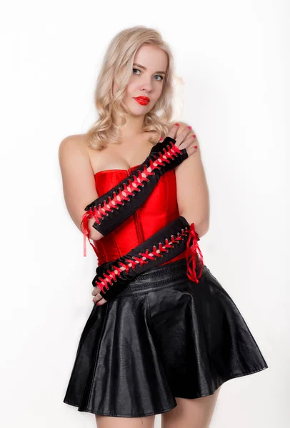 Bella donna bionda sexy con grandi seni in un corsetto rosso e gonna nera corta — Foto Stock