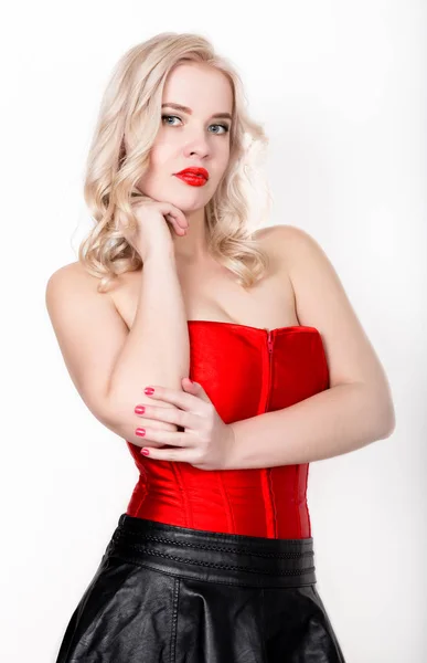 Bela mulher loira sexy com seios grandes em um espartilho vermelho e saia preta curta — Fotografia de Stock