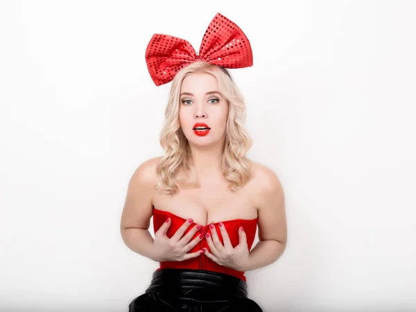 Bella donna bionda sexy con grandi seni in un corsetto rosso e grande fiocco — Foto Stock