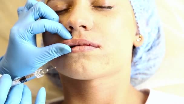 Mujer joven en labio Aumento en una clínica. Inyección anestésica Engrosamiento de labios con implante de silicona. inyección de botox — Vídeo de stock