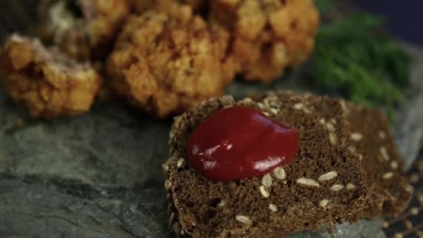 Домашние котлеты в тесте с петрушкой, кетчупом и хлебом на камне — стоковое видео
