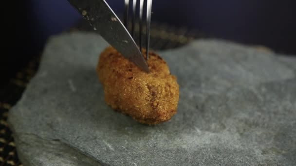 Homemade meat cutlets in batter with parsley, ketchup and bread on stone, woman cutting food to knife — Stock Video