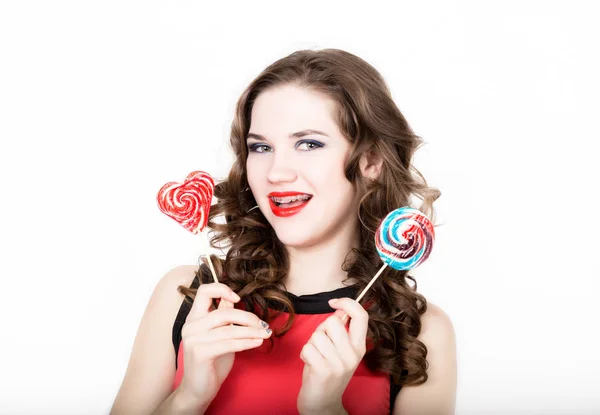 Retrato de mujer joven y hermosa con frenos dentales que sostienen el azucarillo — Foto de Stock